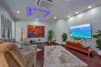 5 Bedroom House for Sale & Rent in Pratumnak Hill living room with red abstract painting, large flat-screen TV, dark hardwood floors and shag rug
