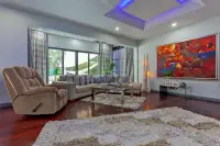 5 Bedroom House for Sale & Rent in Pratumnak Hill bright living room with recliner, sectional sofa, glass coffee table and garden view windows