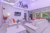 4 Bedroom House for Sale & Rent in Pratumnak Hill lounge area with white leather sofas, wall-mounted TV, and jazz band ceiling mural