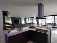 7 Bedroom House for Sale & Rent in Pratumnak Hill modern kitchen island with built-in stove and glass walls overlooking garden