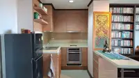 1 Bedroom Condo for Sale at Prime Suites kitchen with built-in oven, wood cabinets and decorative wall art