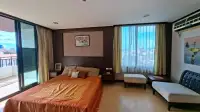 1 Bedroom Condo for Sale at Prime Suites master bedroom with orange bedspread, balcony access and city view