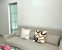 3 Bedroom House for Sale in East Pattaya sofa with patterned throw pillows near glass door entrance
