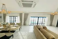 3 Bedroom House for Sale in Nong Prue bright living and dining area with gold chandelier marble floors and pool-view glass doors