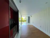 1 Bedroom Condo for Sale at Pure Sunset Beach living space with kitchenette and sliding glass doors to pool view