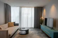 1 Bedroom Condo for Rent at Beverly Mountain Bay Pattaya living area with sheer curtains and teal TV console