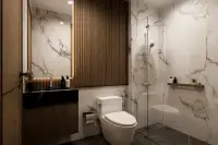 1 Bedroom Condo for Sale at Siam Oriental Beach: Modern bathroom with marble walls, glass shower, and vanity.