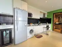 1 Bedroom Condo for Sale at The Park Jomtien kitchen with fridge, washing machine and black tile backsplash