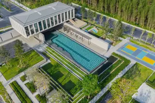 Cascade modern two-story house exterior with carport, large windows, and decorative water feature.