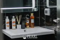 1 Bedroom Condo for Sale at Grand Solaire Pattaya: Bathroom vanity with white sink, black faucet, and various toiletries.