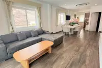 3 Bedroom House for Sale at Royal Prestige open-plan living and dining area with grey sectional sofa and wood-look flooring