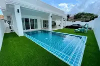 5 Bedroom House for Rent at Casa Jomtien private swimming pool with tiled surround, green lawn, and covered patio