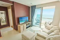 1 Bedroom Condo for Sale & Rent at Palm Wongamat living room with sofa, TV and balcony ocean view