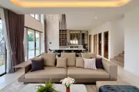 3 Bedroom House for Rent at Horizon By Patta spacious open-plan living and dining area with double-height marble feature wall and chandelier