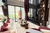 5 Bedroom House for Sale at Harmony Hills Villas Pattaya spacious living area with large TV, red curtains, and outdoor view.