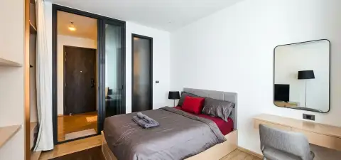 1 Bedroom Condo for Sale at EDGE Central Pattaya bedroom with gray and red bedding and wall mirror