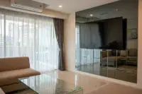 2 Bedroom Condo for Sale at The Elegance living room with mirrored TV wall unit, sheer curtains and balcony access
