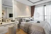 Studio Condo for Sale at Seaspire Jomtien: Bedroom area with large bed, vanity, and floor-to-ceiling windows.