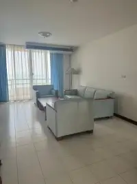 2 Bedroom Condo for Rent at Rama Harbour View living room with light blue sofas and balcony sliding doors