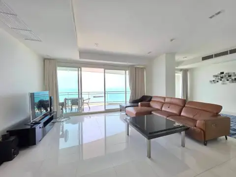 3 Bedroom Condo for Rent at Reflection Jomtien Beach spacious living area with sectional sofa and glass balcony doors