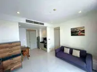 1 Bedroom Condo for Sale at Reflection Jomtien Beach open-plan living room with sofa and kitchenette