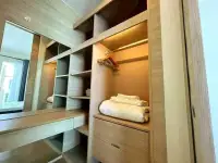 1 Bedroom Condo for Sale at Reflection Jomtien Beach walk-in closet with built-in wooden shelving