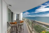 3 Bedroom Condo for Sale at Reflection Jomtien Beach balcony seating area with bistro table overlooking beach and ocean