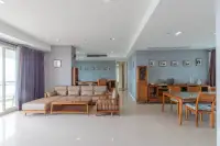 3 Bedroom Condo for Sale at Reflection Jomtien Beach living and dining area with wooden furniture and blue walls