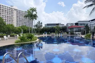 Rimhad Jomtien Condominium S2 pool deck with loungers, greenery and nearby buildings