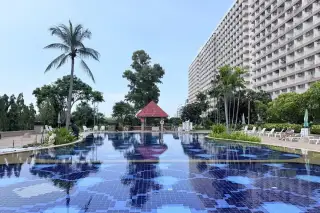 Rimhad Jomtien Condominium S2 outdoor pool with red-roof gazebo, palm trees and high-rise tower