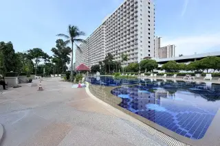 Rimhad Jomtien Condominium S2 poolside deck with loungers and view of residential tower