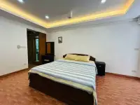 1 Bedroom Condo for Sale at Rimhad Jomtien Condominium bedroom with dark wood bed frame and recessed ceiling lighting