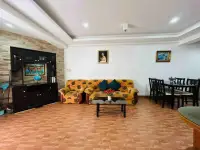 1 Bedroom Condo for Sale at Rimhad Jomtien Condominium living room with sofa, dining table, and stone accent wall unit