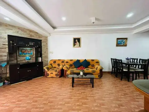 1 Bedroom Condo for Sale at Rimhad Jomtien Condominium living room with sofa, dining table, and stone accent wall unit