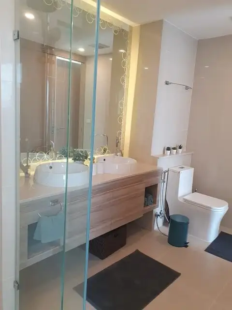 2 Bedroom Condo for Sale at The Riviera Jomtien bathroom with glass shower, double vanity sinks and modern mirror