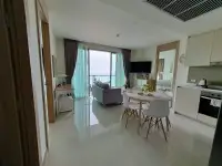 2 Bedroom Condo for Sale at The Riviera Jomtien open living room, dining and kitchen with ocean view window