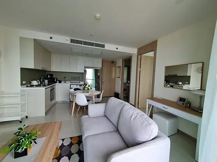 2 Bedroom Condo for Sale at The Riviera Jomtien open-plan kitchen with white cabinets and dining area
