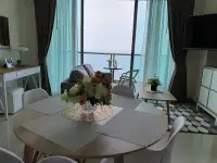 2 Bedroom Condo for Sale at The Riviera Jomtien living and dining area with round table and sea view balcony