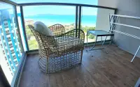 1 Bedroom Condo for Sale & Rent at Riviera Monaco private balcony with rattan chair and ocean view