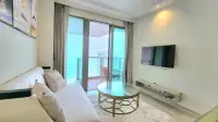 1 Bedroom Condo for Rent at Riviera Monaco living area with wall-mounted TV and sliding doors to balcony