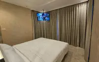 2 Bedroom Condo for Sale & Rent at Riviera Monaco cozy bedroom with wall-mounted TV and floor-to-ceiling curtains