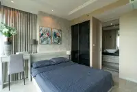 2 Bedroom Condo for Sale at Riviera Monaco master bedroom with navy bedding and tropical wall art