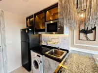 1 Bedroom Condo for Sale at Riviera Monaco compact kitchen with black fridge and pebble-tile floor accent