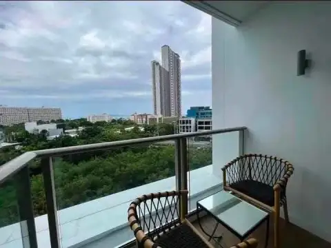 1 Bedroom Condo for Rent at Riviera Ocean Drive private balcony with rattan chairs and high-rise skyline view