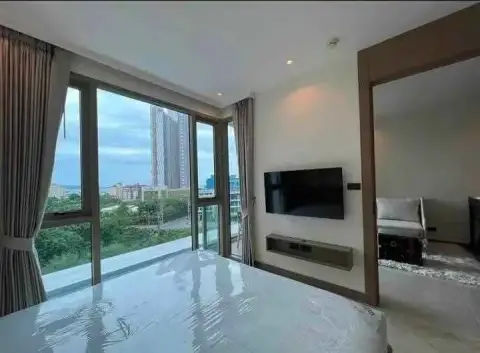 1 Bedroom Condo for Rent at Riviera Ocean Drive bedroom with wall-mounted TV and floor-to-ceiling windows