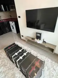 1 Bedroom Condo for Rent at Riviera Ocean Drive wall-mounted TV with trunk-style coffee table and rug