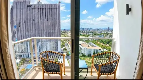 1 Bedroom Condo for Rent at Riviera Ocean Drive private balcony with rattan chairs overlooking Pattaya skyline