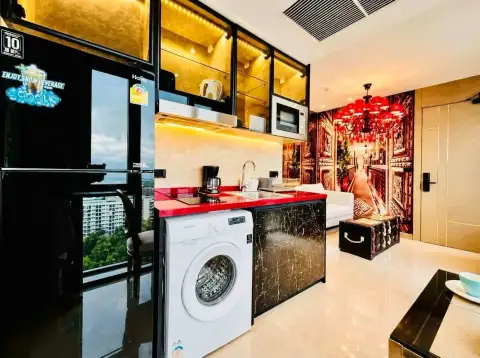 1 Bedroom Condo for Rent at Riviera Ocean Drive compact kitchenette with washing machine and decorative wall mural