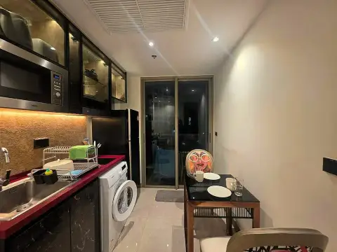 1 Bedroom Condo for Rent at Riviera Ocean Drive compact kitchen with dining table and balcony door at night