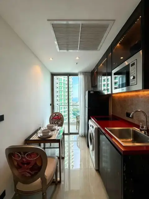 1 Bedroom Condo for Rent at Riviera Ocean Drive compact kitchen with red countertop, dining nook, and balcony access